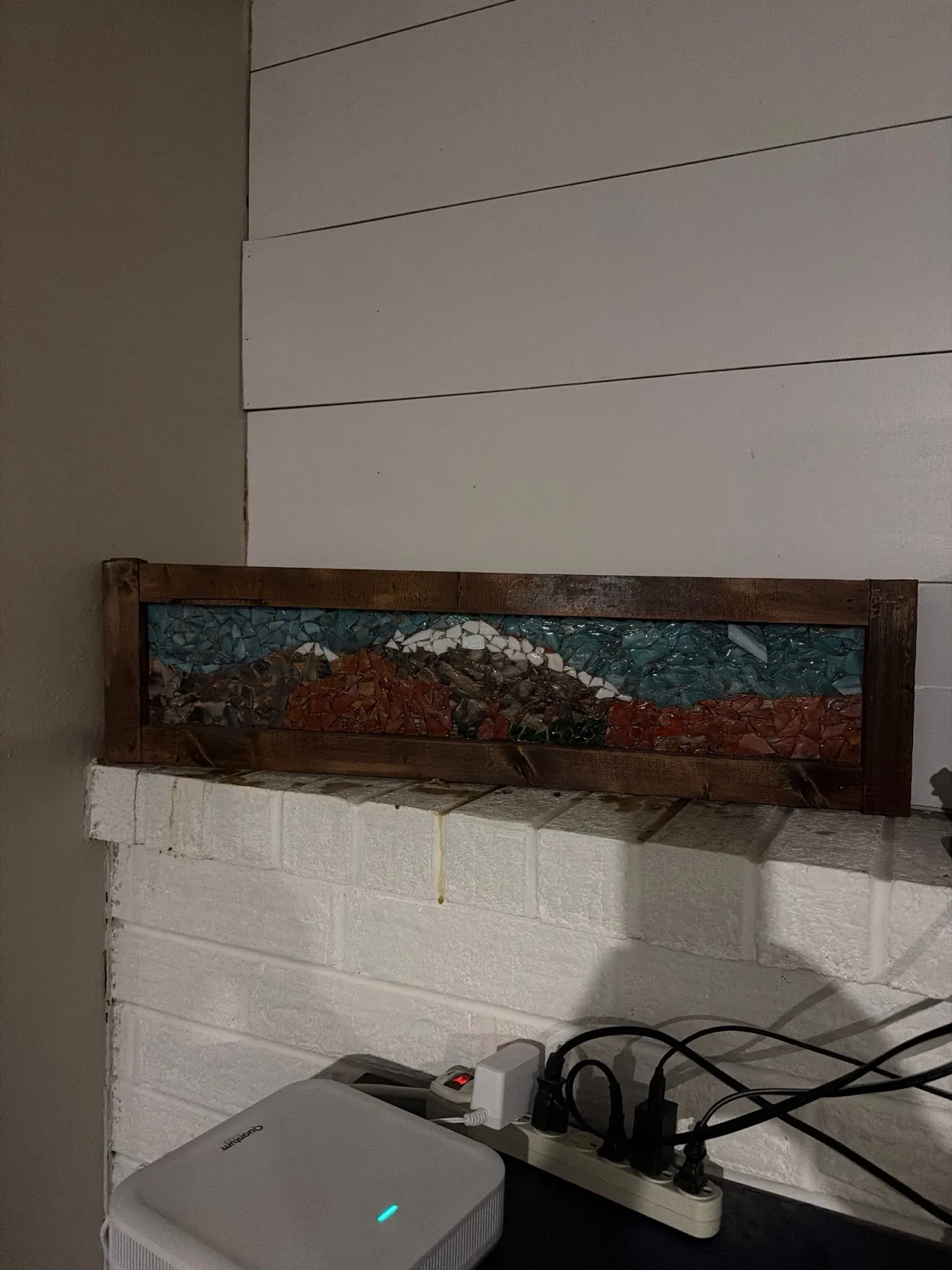 Framed hand-cut mountain mosaic panel displayed on a mantel