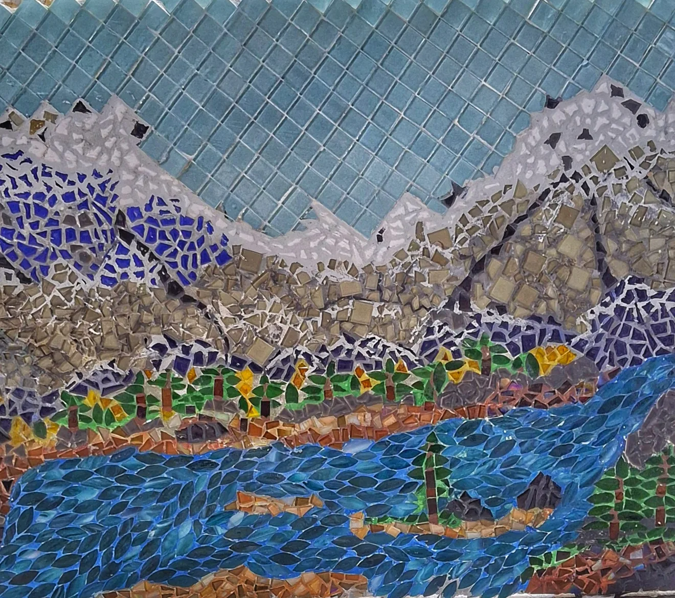 Close-up of a hand-cut mountain river mosaic showing individual cut glass and stone pieces